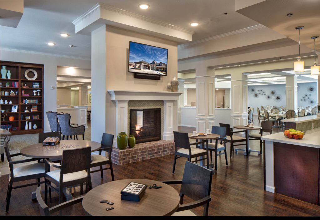 Jim Wilson3D3A5821RT1ABAA - Twin Rivers Cafe tables are set near a fire place in the community bistro at Twin Rivers, an assisted living and memory care community near Garland, TX.